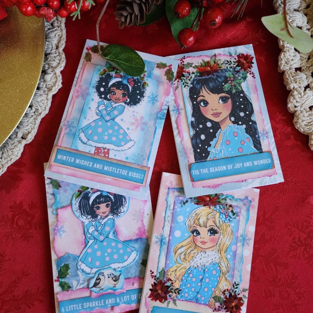 Vintage Winter Girls DIY Craft Kit displayed on a festive red table with four holiday-themed greeting cards for crafting and personalization.